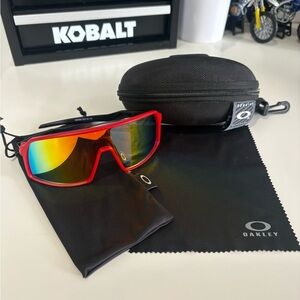 Oakley Red Frame Sunglasses with Rainbow Lenses and Black Accessories